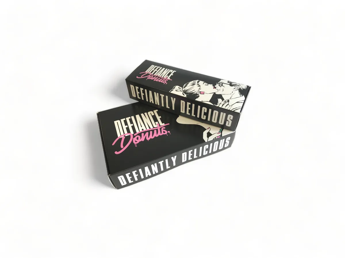 Two printed Defiance Donuts boxes with Defiantly Delicious branding